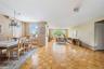 Spacious open-concept living and dining areas featuring parquet wood flooring throughout