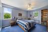 Bedroom featuring blue wall paint, blue carpeting, and multiple windows