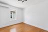 Hardwood flooring room with a single window, white walls, and a mini-split air conditioning unit
