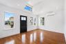 Entry area featuring a dark paneled door with glass inserts, wood-finish flooring, and white walls