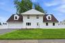 Two-story residence featuring white vinyl siding and a dark shingle roof