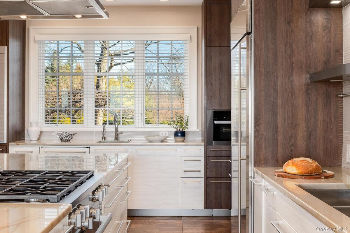 The sunlit kitchen boasts every amenity including 3 sinks , 2 dishwashers and walk-in pantry.