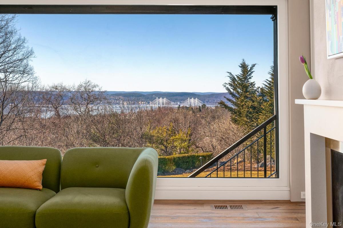 Panoramic windows offer stunning views of the Hudson River and beyond.
