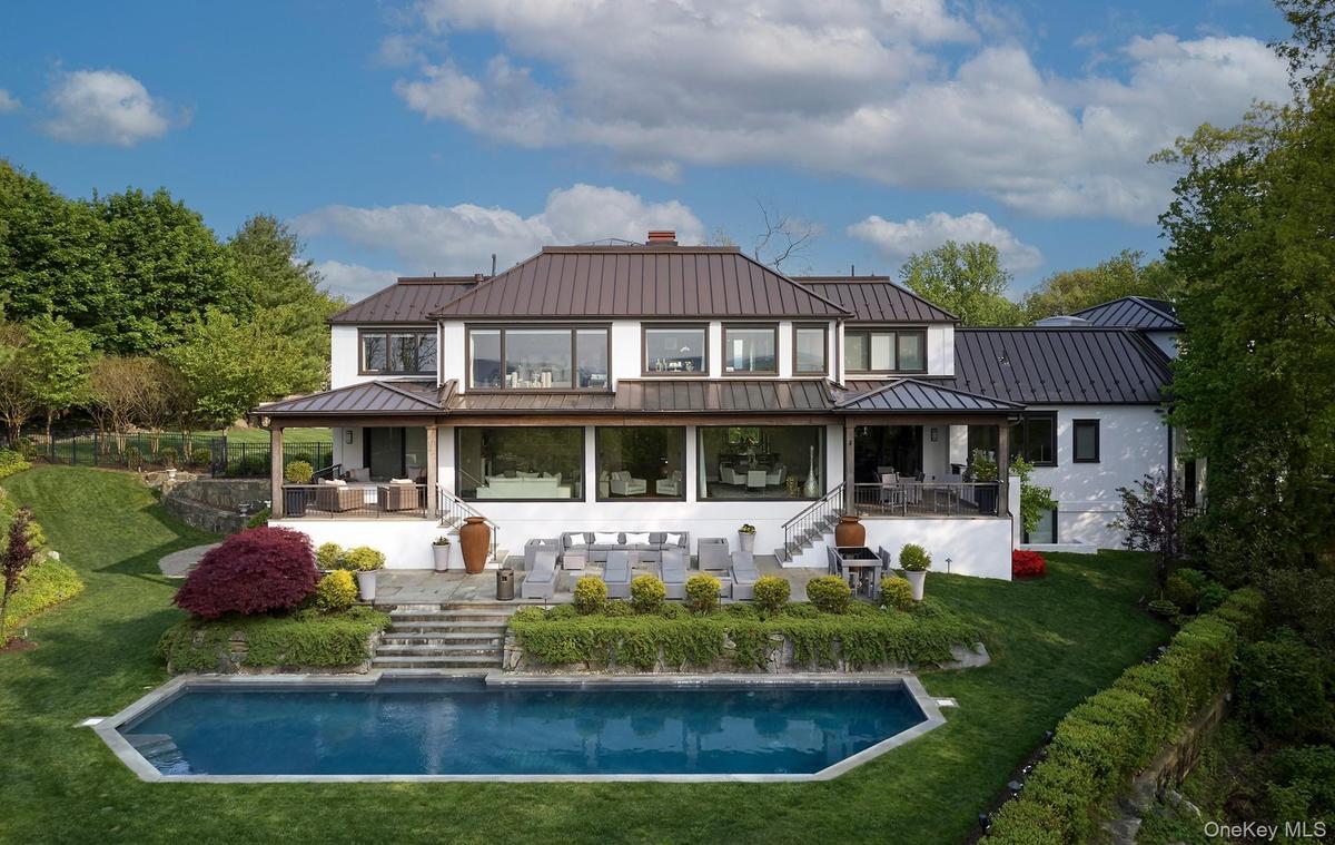 Rear view of house with heated salt water pool and multiple outdoor living areas.