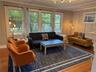 Living room with wood finished floors, healthy amount of natural light, a chandelier, and ornamental molding