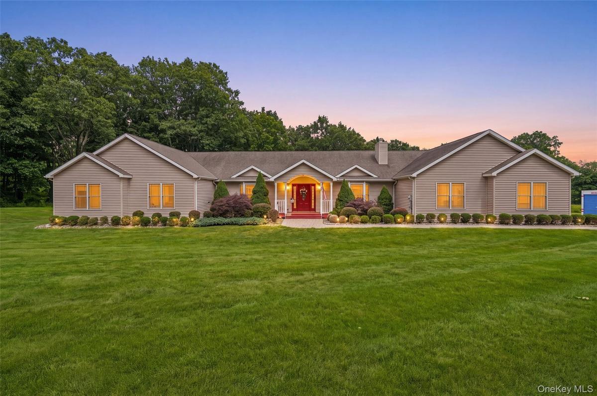 Single-story home featuring a broad front lawn
