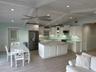 Open living area with a vaulted white wood ceiling and exposed trusses.