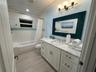 Refreshing and inviting bathroom. Window that allows a gentle breeze. The crisp white tiles and sleek fixtures create a clean and classic aesthetic. A