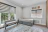 Room featuring wood-finish flooring, light grey walls, and white crown molding.