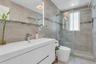 Contemporary bathroom featuring a floating white vanity with integrated sink, chrome faucet, and an illuminated mirror