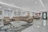 Expansive open concept living area featuring large polished tile flooring, recessed, and cove ceiling lighting, and ceiling crown and floor molding