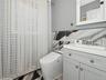 Bathroom featuring vanity, tile walls, and toilet
