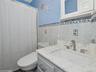 Bathroom featuring vanity, toilet, and tile walls
