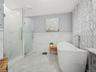 Bathroom with plus walk in shower, vanity, and tile walls