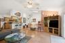 Living Room to kitchen and stairs with vaulted ceilings and skylight.