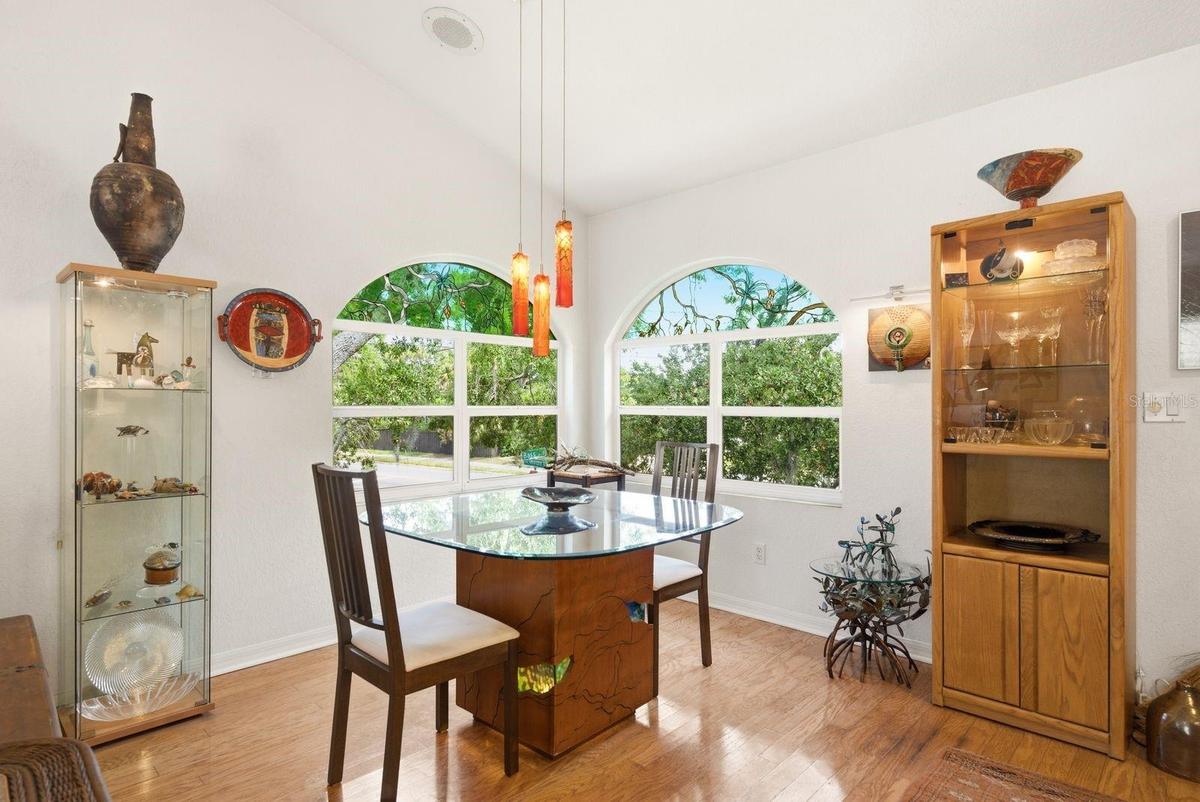 Dining area overlooks front and side yard with custom windows, light fixture handmade by artist from Azerbaijan.