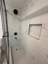 Bathroom featuring a marble finish shower and ornamental molding