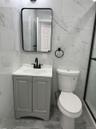 Full bath with tile walls, vanity, and a marble finish shower
