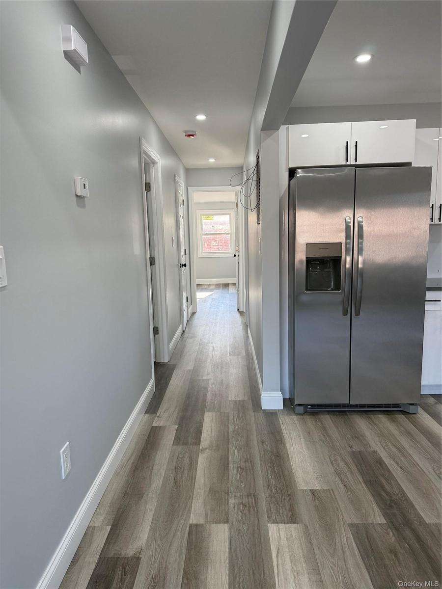 Corridor featuring light wood-type flooring and recessed lighting