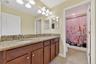 Full Bathroom with Dual Vanities, Granite Countertops, and Shower/Tub Combination.