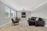 Living Room with Crown Molding, 3 Stunning Windows, Accent Wall with Stone Accent and Chandelier.