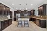 Full Gourmet Kitchen with Crown Molding, Island, Pendant & Recessed Lighting, Abundant Cabinets with Crown Trim, Granite Countertops, Backsplash, GE S