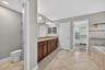 Primary En-Suite Bathroom with Dual Vanities, Granite Countertops, Garden Soaking Tub with Window, Shower Stall with Glass Frame, Private Water Closet