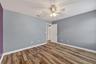 Bedroom #3 with LVP Flooring, Ceiling Fan, Walk-In Closet, Accent Wall and Window.