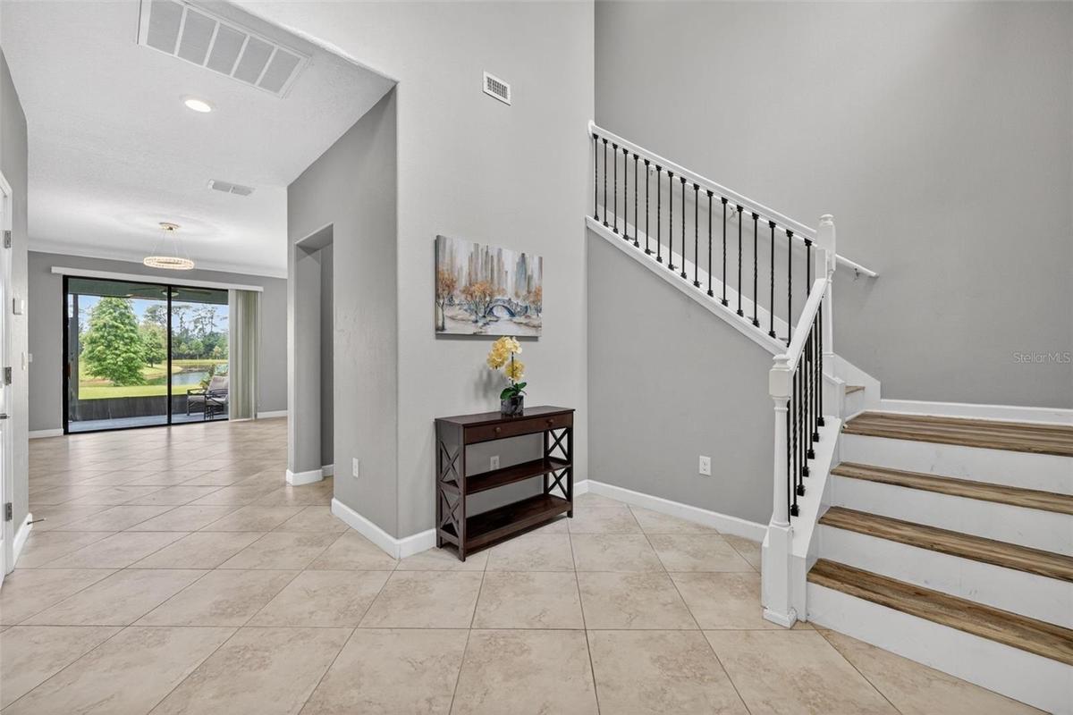 Foyer with Cathedral High Ceiling, View to Tranquil Pond, Alcove, and Staircase