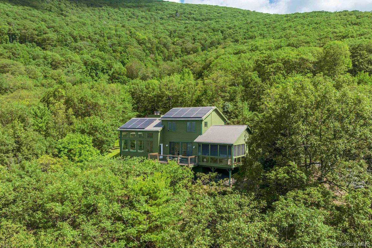 Aerial view of property and surrounding area with  wooded area