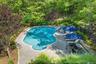 Pool with outdoor kitchen and fire pit.