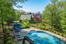 View of fenced  swimming pool, outdoor kitchen and fire pit.