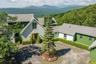 View of front of home with a mountain view and circular driveway.