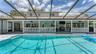View of pool and covered porch under screen(previously staged)
