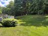 Beautiful backyard with fence and woods beyond.