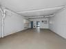 The covered parking with the doors open through the ground floor bonus room