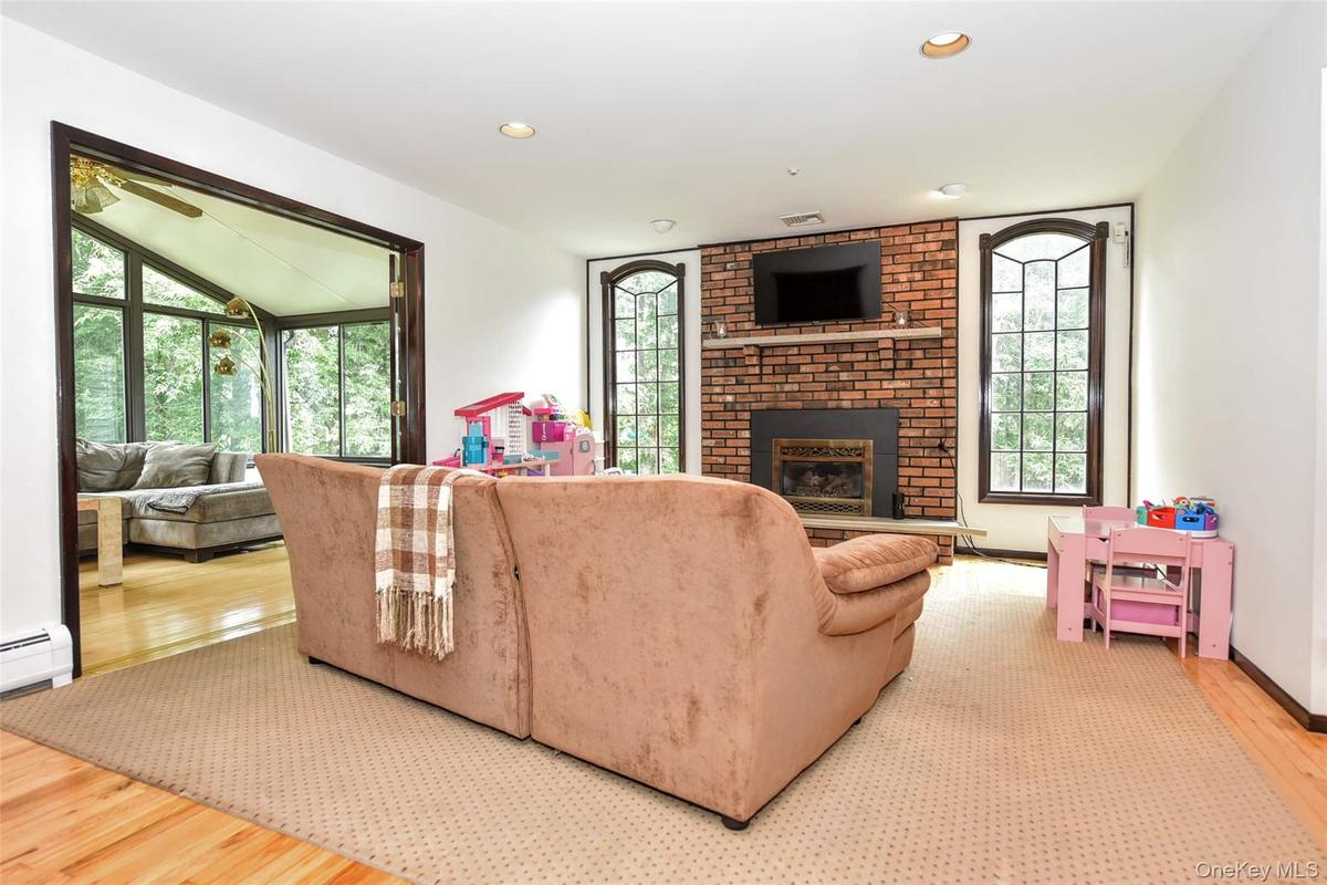 Family Rm with wood burning fireplace and bright arched windows