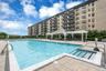 Expansive outdoor pool area featuring a large swimming pool,  and a surrounding paver patio