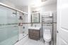 Full bath with tile walls, combined bath / shower with glass door, vanity, and light tile patterned floors