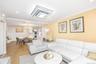 Living room featuring recessed lighting, ornamental molding, wood finished floors, and stacked washer / dryer