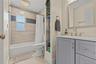 Hall bathroom with updated tile and vanity. Tub shower combo.