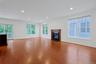The expansive living room is anchored by a handsome gas fireplace and framed by large windows that fill the space with natural light throughout the da