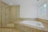 Unwind in the oversized soaking tub or enjoy the separate glass-enclosed shower, creating a true retreat for everyday living.