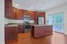 The granite island serves as the heart of the kitchen, offering seating, prep space, and additional storage.