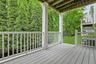 Enjoy morning coffee or evening relaxation on the covered deck overlooking mature landscaping and lush greenery, offering a peaceful extension of the 
