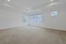 The spacious primary suite offers a peaceful retreat with a tray ceiling, abundant natural light, and ample room for a king-sized bedroom set and sitt