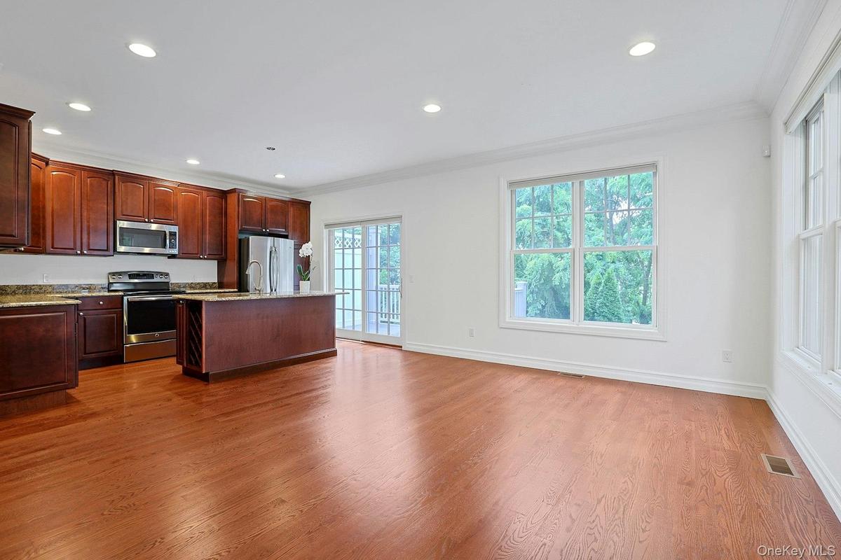 Well-appointed with rich wood cabinetry, granite countertops, stainless steel appliances, and a center island with seating.