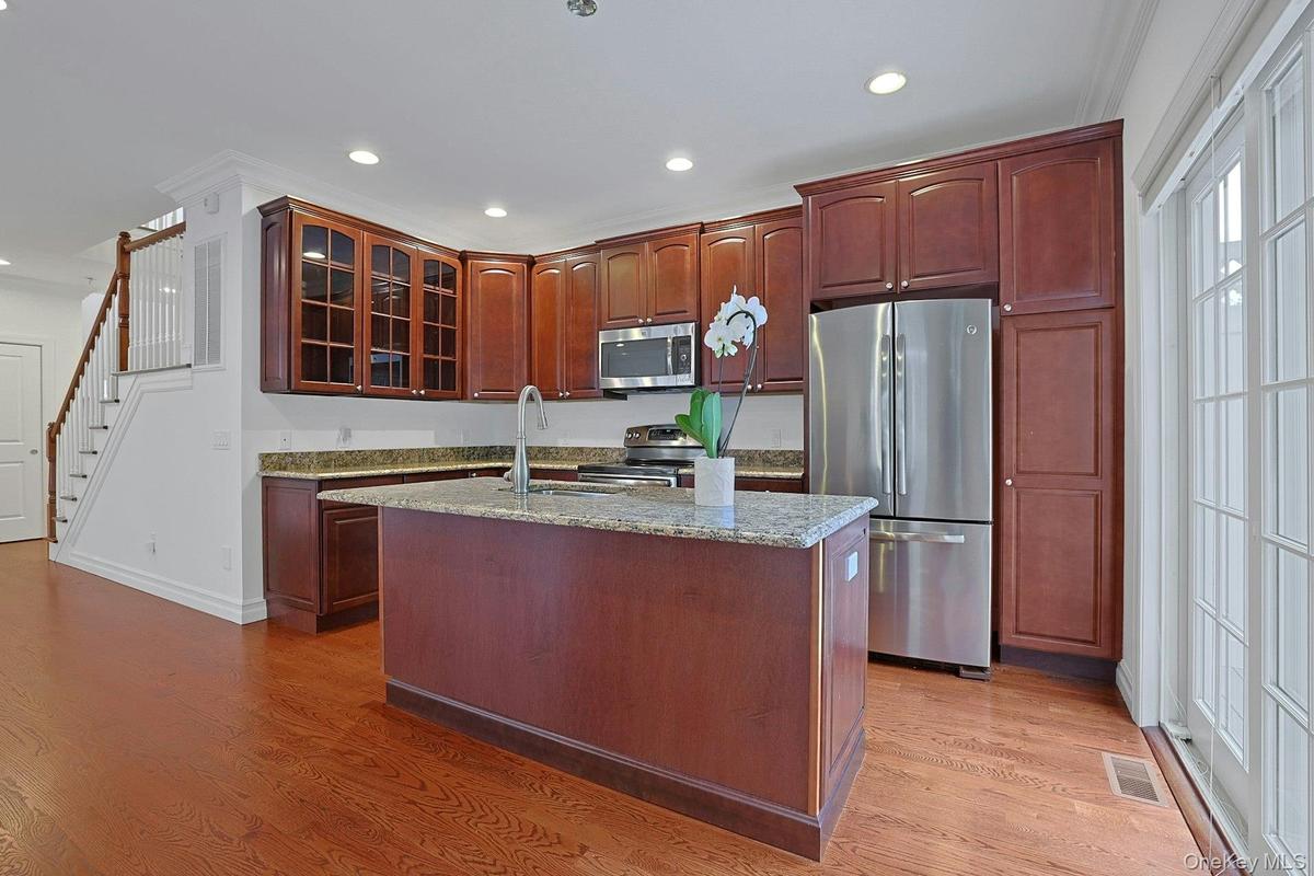 Sliding glass doors connect the kitchen to the private Trex deck, creating the perfect setting for outdoor dining or morning coffee surrounded by gree