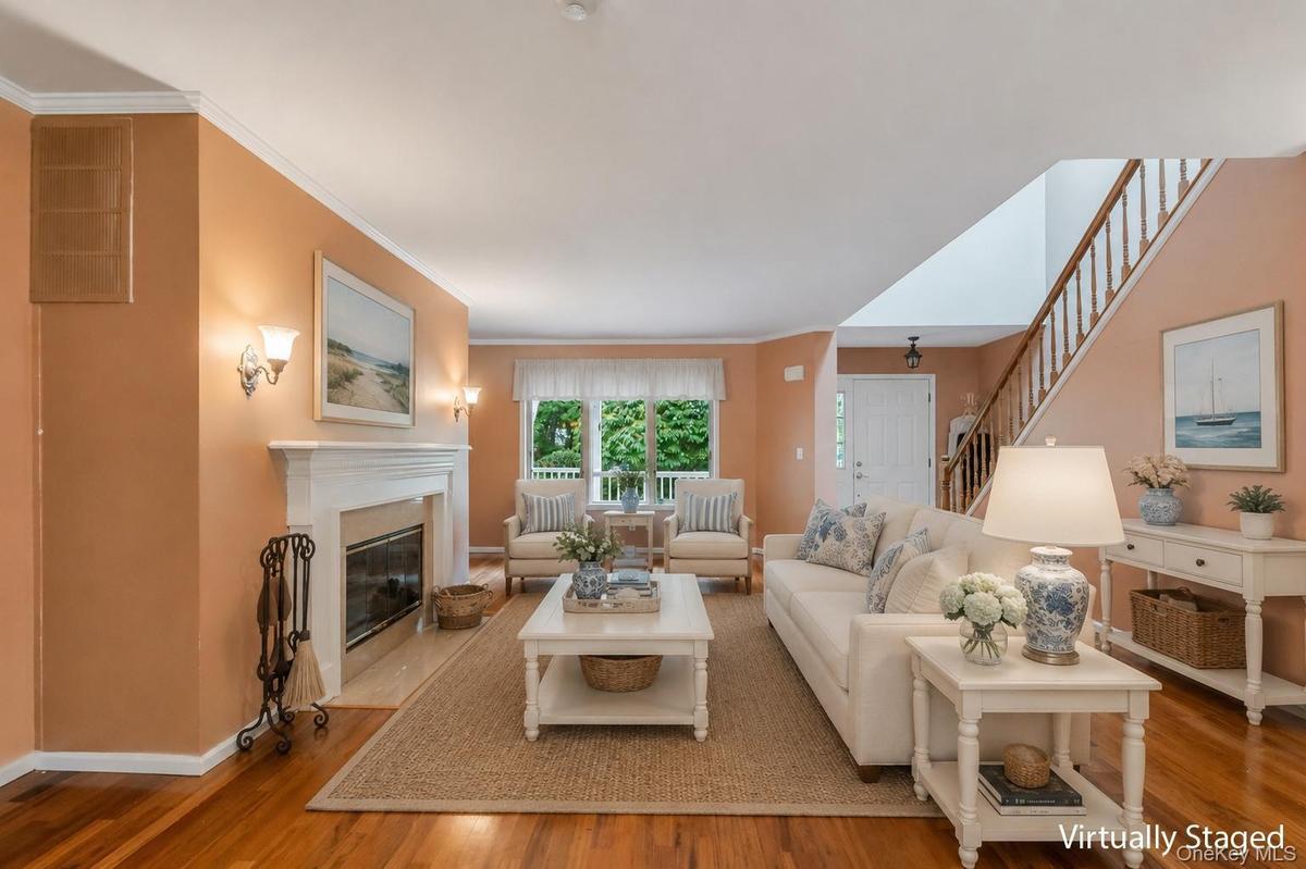 Living room has beautiful polished hardwood floors and crown molding throughout window treatment stay