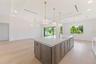 The gourmet kitchen is a true showpiece, featuring full-height custom cabinetry, an oversized 11-foot quartz island with storage on both sides, marble